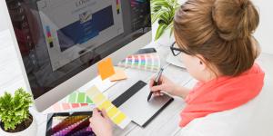 Why Small Business Owners Need to Start Taking Design More Seriously white woman working on a logo for a small business holding yellow paint chip