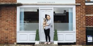 How to Change an Existing Business Name woman standing with dog outside grooming parlor
