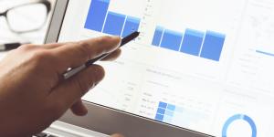 Measuring Success: How to Optimize Performance with Key Small Business Metrics person looking at internet metrics and website traffic on laptop