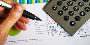 Photo of a hand with pen and calculator