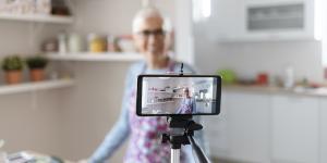 4 Questions to Ask — and Answer — Before Starting a Side Hustle Senior female filming a cooking vlog