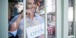 Business owner with Open sign.