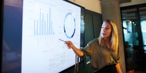 7 Key Pieces of Data to Track as a One-Person Marketing Department woman presenting business metrics