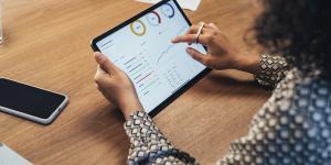 How To Use Google Analytics Data To Inform Business Decisions woman using tablet with graphs and analytics on it