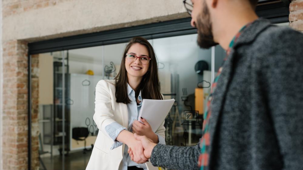Female interviewer shakes hand of prospective employee