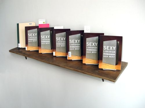 'Untitled' (All the library-owned copies of Sexy Librarian I was able to borrow), Library books written by the artist, handmade wood from paper (shelf), 2009

Courtesy of (from left to right): MoMA Library, Rochester Public Library, Pratt Institute Library, New York Public Library, Lafayette College Library (Courtesy of the Brooklyn Public Library through Interlibrary Loan), Cooper Union Library, Brooklyn Museum Library