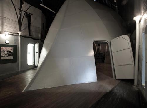 <p>Lindsay Seers. Nowhere Less Now | An Artangel Project | 8 September - 21 October 2012. Installation view: exterior to projection areas. Materials: Wood, cardboard, scaffolding poles, polystyrene, dexion, HD video projection, headphones.</p>