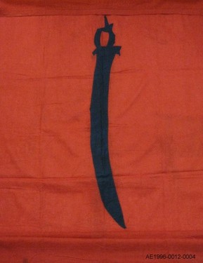 <p>The base colour of this flag refers to the red of most Turkish flags. The pattern is added in an applique technique. It represents a typical Achenese sword, the &lsquo;pedang hulu meu apet&rsquo;. This form was influenced by South Indian sword types.</p>
