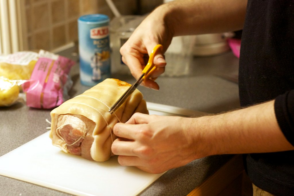 Cutting the rolled pork belly to open it out