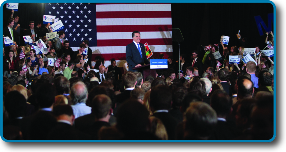 Photo of Mitt Romney in front of a crowd, smiling.