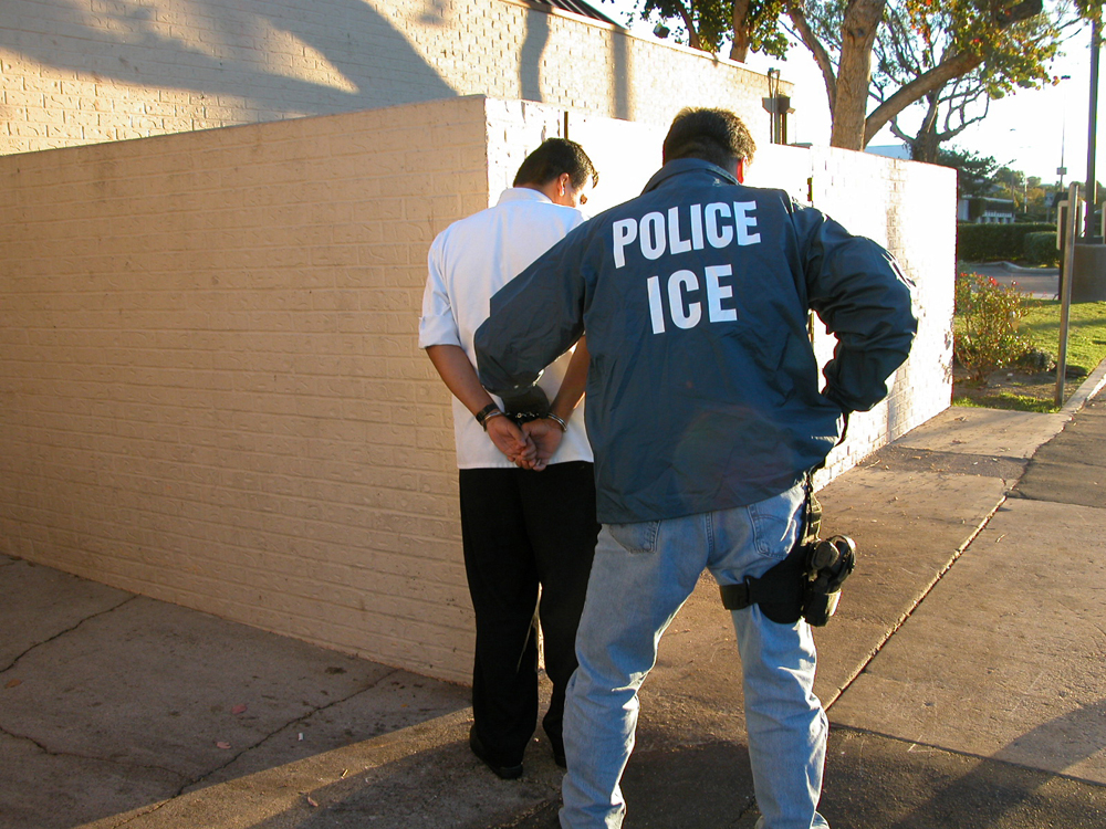 A police officer is shown cuffing a suspect.