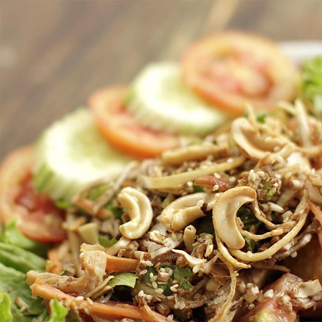 Banana Flower Salad served with tomato and cucmber garnish.