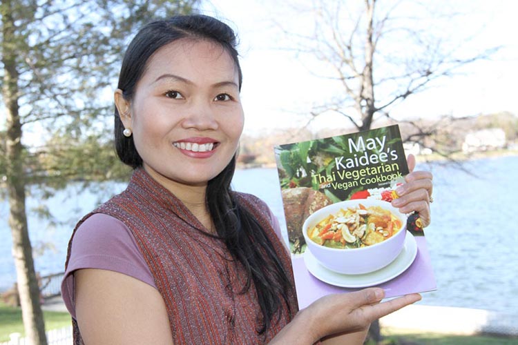 Company founder May holding her cookbook.