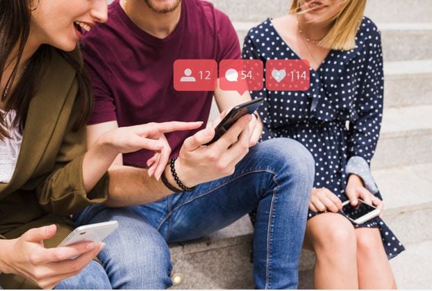 Seguidores falsos no Instagram: imagem de três pessoas interagindo com um celular.