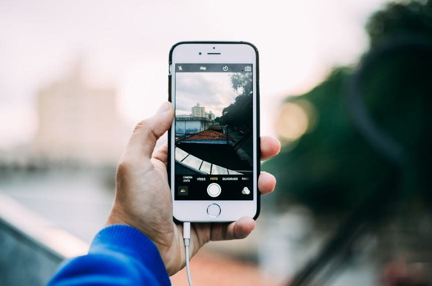 Time Lapse no Instagram: imagem de uma mão segurando o celular com a câmera aberta para tirar foto.