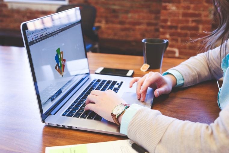 Como fazer um infográfico: imagem das mãos de uma mulher mexendo no computador