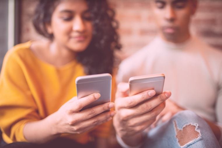 Como divulgar meu blog: duas pessoas olhando para tela dos seus celulares