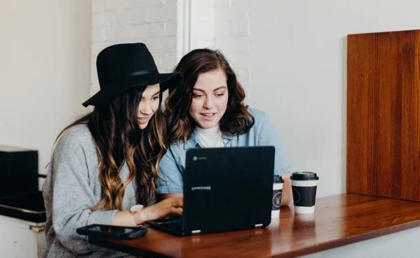 Marketing de influência: imagem de duas mulheres olhando na tela no notebook