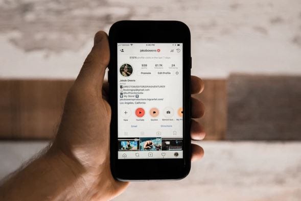 Ganhar seguidores no Instagram: imagem de uma mão segurando o celular com a tela do Instagram aberta