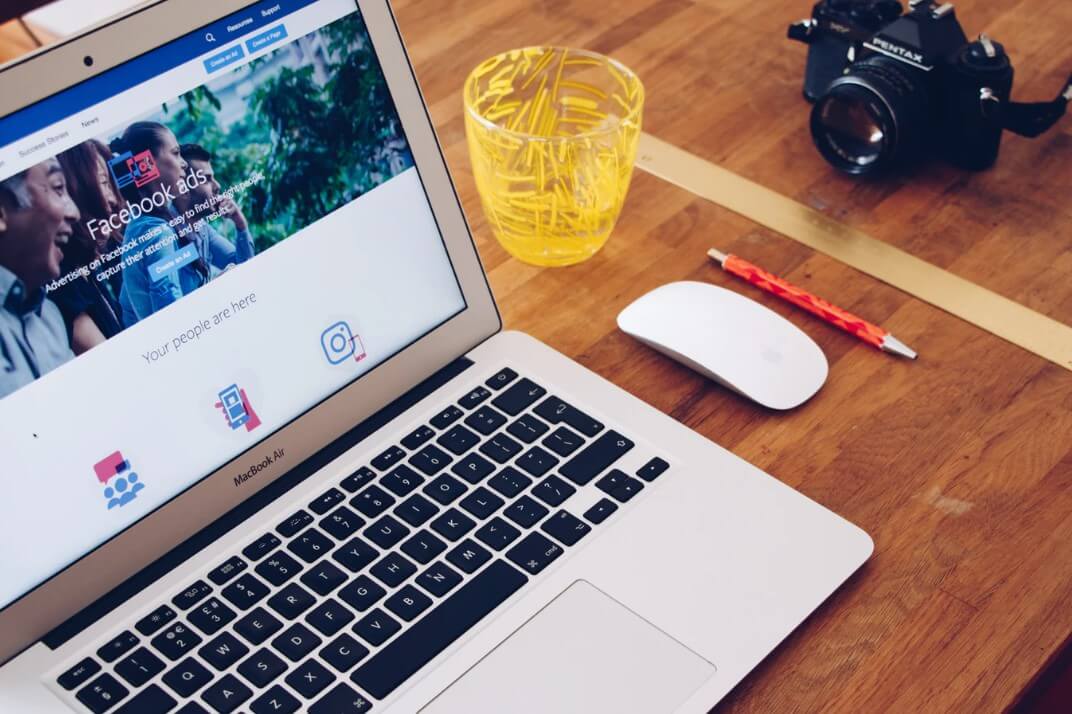 Criativo dinâmico do Facebook: imagem de um notebook em cima de uma mesa de madeira com a tela do Facebook Ads aberta.