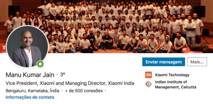 Perfil linkedin: imagem da capa e do perfil do Manu Kumar Jain, vice presidente da Xiaomi. no LinkedIn. A imagem da capa é de várias pessoas da empresa com a mesma camiseta posando para a foto.
