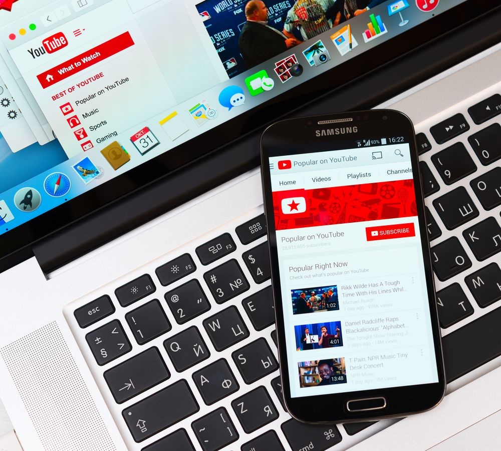 Como vender nas redes sociais: imagem de um notebook e um celular sobre o teclado do notebook com a tela do youtube aberta