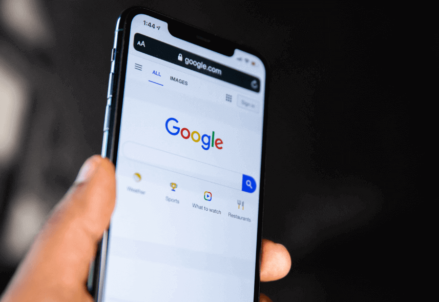 como criar conta no google ads: imagem de uma mão segurando um celular com a tela do Google a mostra
