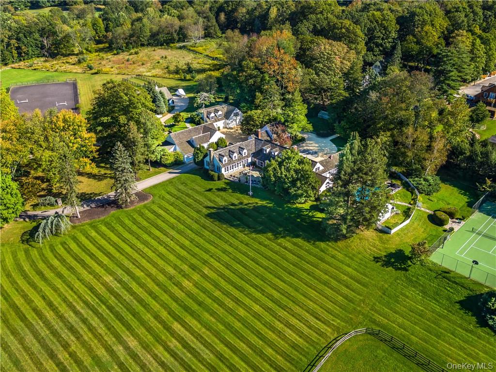 Skyland Farm. Set on one of the most prestigious country lanes, this Bedford estate sits on over 25 acres of spectacular property with rolling land, scenic views and gorgeous landscape. The up-to-the minute, beautifully executed 5 bedroom main residence has a spectacular great room as its focal point with a fieldstone fireplace, barn beam ceilings and an open style designer kitchen extending to both dining and lounging areas. Two bedroom guest cottage, pool, pool house, tennis court, gym house, art studio, sports barn, 5 stall barn with wash stall and tack room, riding ring, paddocks, greenhouse and garaging for 4 cars make this one of the most compelling offerings in the area. The beautiful primary suite includes a walk in dressing closet, wet bath with rain shower, soaking tub, dual sinks and adjacent paneled library/study with fireplace, office and French doors to the pool. Sophistication and style is evidenced throughout the estate. The property is on the BRLA for amazing walking and riding and is less than 1 hour to NYC.