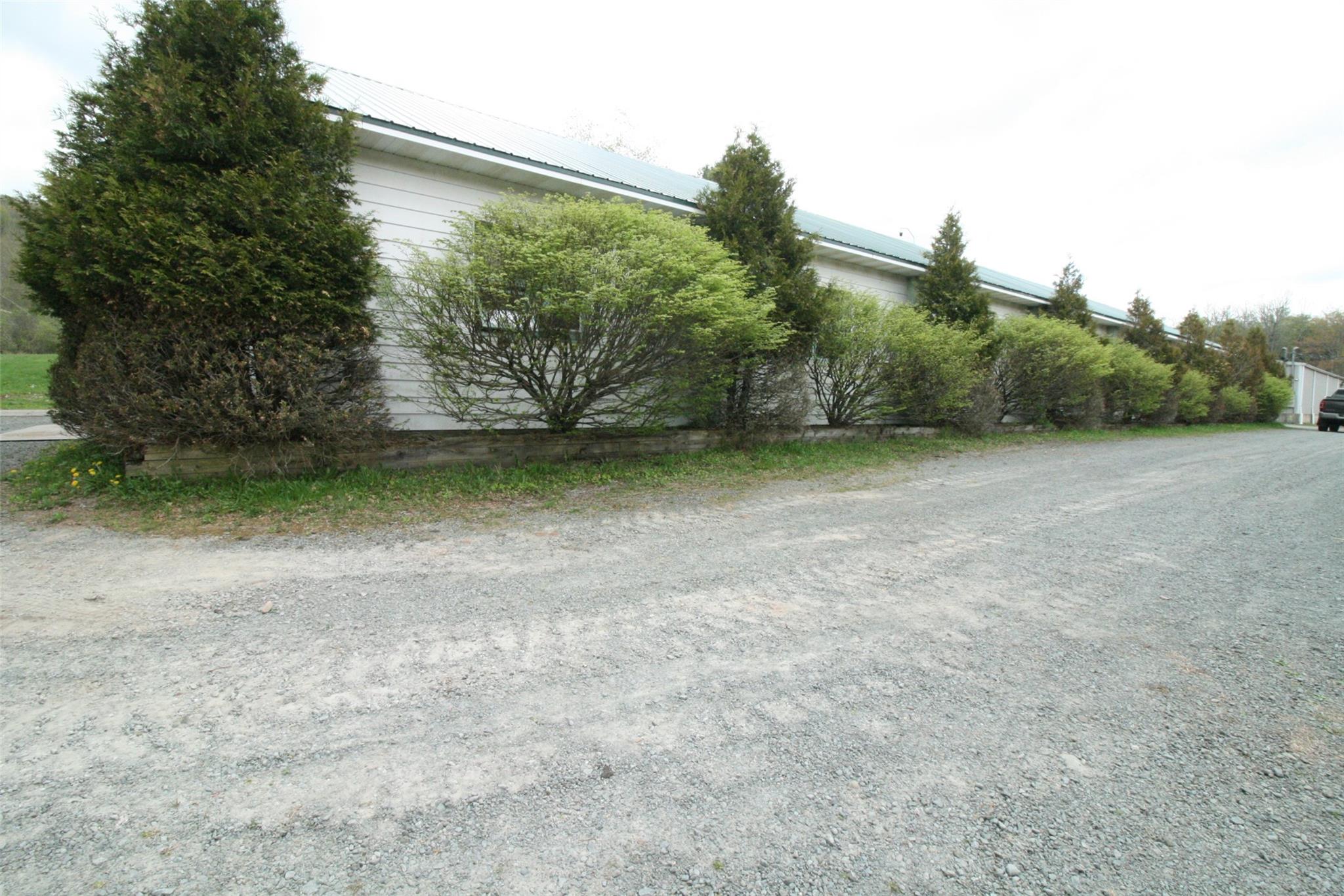 Commercial lease space available in the western part of Sullivan county. These two buildings connected by a wide enclosed hallway currently has several office spaces, storage spaces, and huge open high layout. With many large garage doors, three bathrooms, airlines throughout, large loft area, and three phase electric this can be used for a multitude of needs. Property being leased per sq ft. Lease the total sq footage of the connected two buildings or choose which building to lease