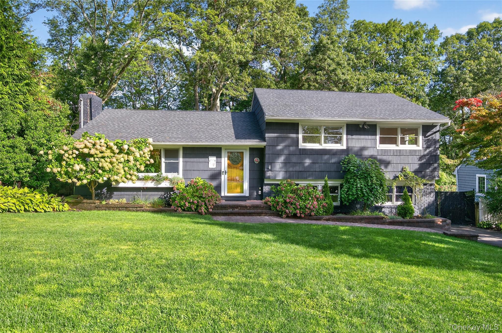 Newly Renovated home in Centerport! Beautifully updated in 2022 this home is move-in ready with stylish finishes and functional design with hardwood floors throughout. The living room features a lovely picture window overlooking the front yard and a gas fireplace. While the kitchen boasts brand-new black stainless steel appliances, two-toned cabinets, granite countertops and a white birch porcelain tile floor. Upstairs, the primary bedroom offers large double closets as well as two additional generously sized bedrooms. The stunning new black and white full bath features a whirlpool tub and a sleek shower accented with modern black hardware. The lower family room includes a half bath, direct access to the garage and a walk-out to the back patio. Outdoors, enjoy beautifully landscaped gardens, a brick patio, a large koi pond with a waterfall and an additional bog, creating a peaceful retreat. The extra-deep attached one-car garage is tucked behind a private gate, adding convenience and security. Located in the Harborfields School District and just minutes from local beaches, this home is a true gem.