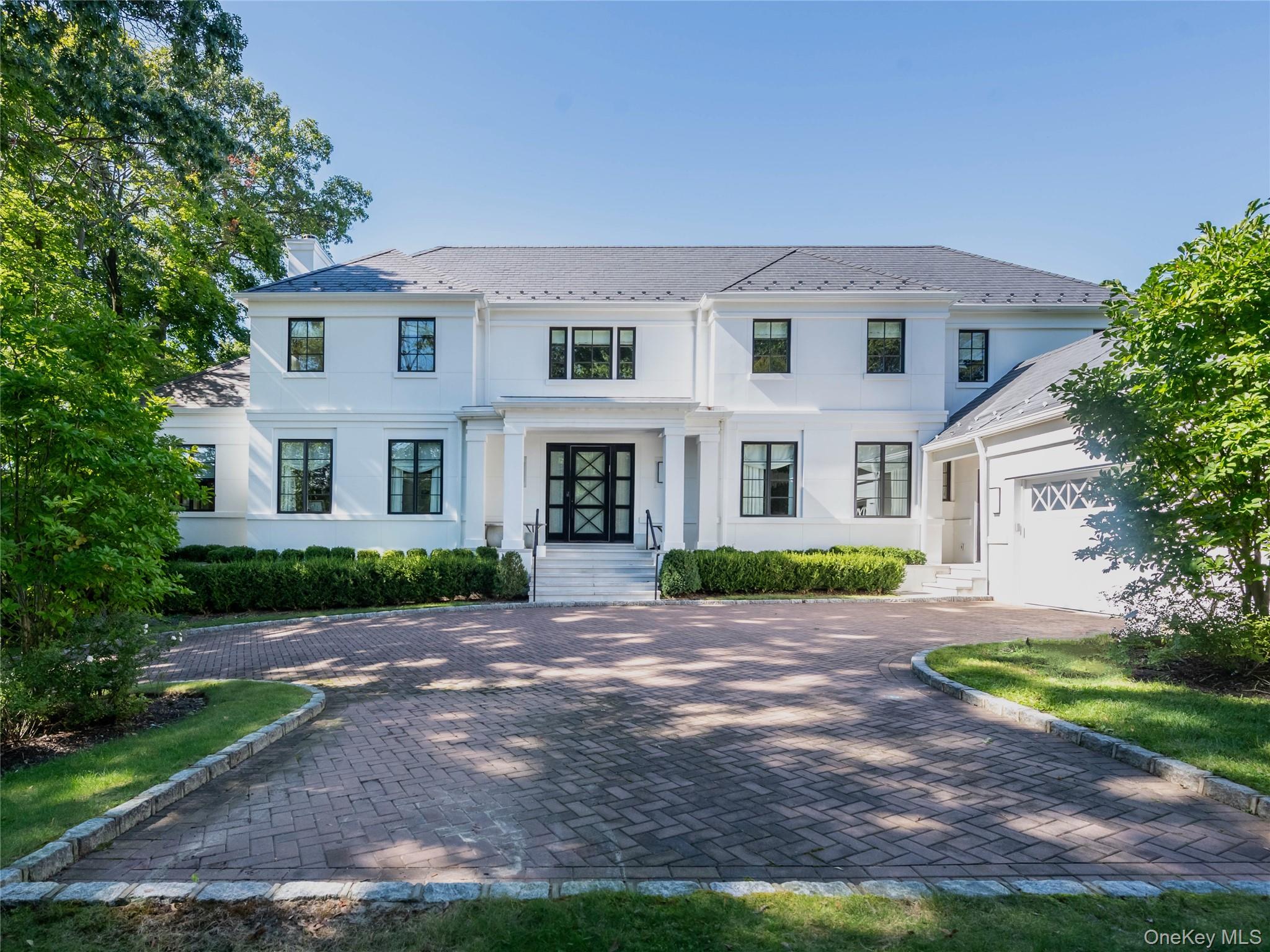 French Modern residence, built in 2018, seamlessly blends contemporary luxury with timeless design. Perched on a prime setting and offering over 7, 000 square feet of refined living, the home presents a stately facade with a columned portico, dramatic windows, and iron-framed glass doors that open to a museum-inspired foyer with marble floors and art niches. The main level is designed with comfort, elegance, and entertaining, featuring spacious living and dining rooms, a bright private study, powder room, library with custom built-ins, and a guest suite with en-suite bath. The inviting family room extends through French doors to the terrace and heated pool, creating seamless indoor-outdoor living. Additional highlights include an extra half bath, back staircases, and an attached garage. High, uniquely styled tray ceilings, intricate moldings, and pocket doors enhance the homeâ€™s flow and architectural character.The chefâ€™s kitchen is a true centerpiece, boasting marble counters, three Sub-Zeros, five ovens, an eight-burner stove, three Miele dishwashers, and a sunlit breakfast room overlooking the lush yard.A striking custom staircase with bold geometric iron balustrades leads to the second level, which offers five bright ensuite bedrooms, each with distinctive tray ceiling designs. The luxurious primary suite features a spa-like bath with artistic mosaic tilework, a magical balcony with seasonal water views, generous custom closets, and the convenience of an upstairs laundry room.The full lower level expands the living space with three additional bedrooms, four full baths, a second kitchen, a den, a playroom, a glass-walled gym, a wine cove, a recreation area, and a secondary laundry with two washers and two dryers. High ceilings and a walk-out design enhance the sense of light and space.Additional features include radiant heat warming all stone floors throughout, a full-house generator, and an elevator shaft already in place for future installation. Outdoors, manicured landscaping and mature hedgerows provide privacy around the expansive bluestone terrace, lush lawn, and heated pool.Located in the prestigious Village of Great Neck Estates MUST SEE! A true standout residence!