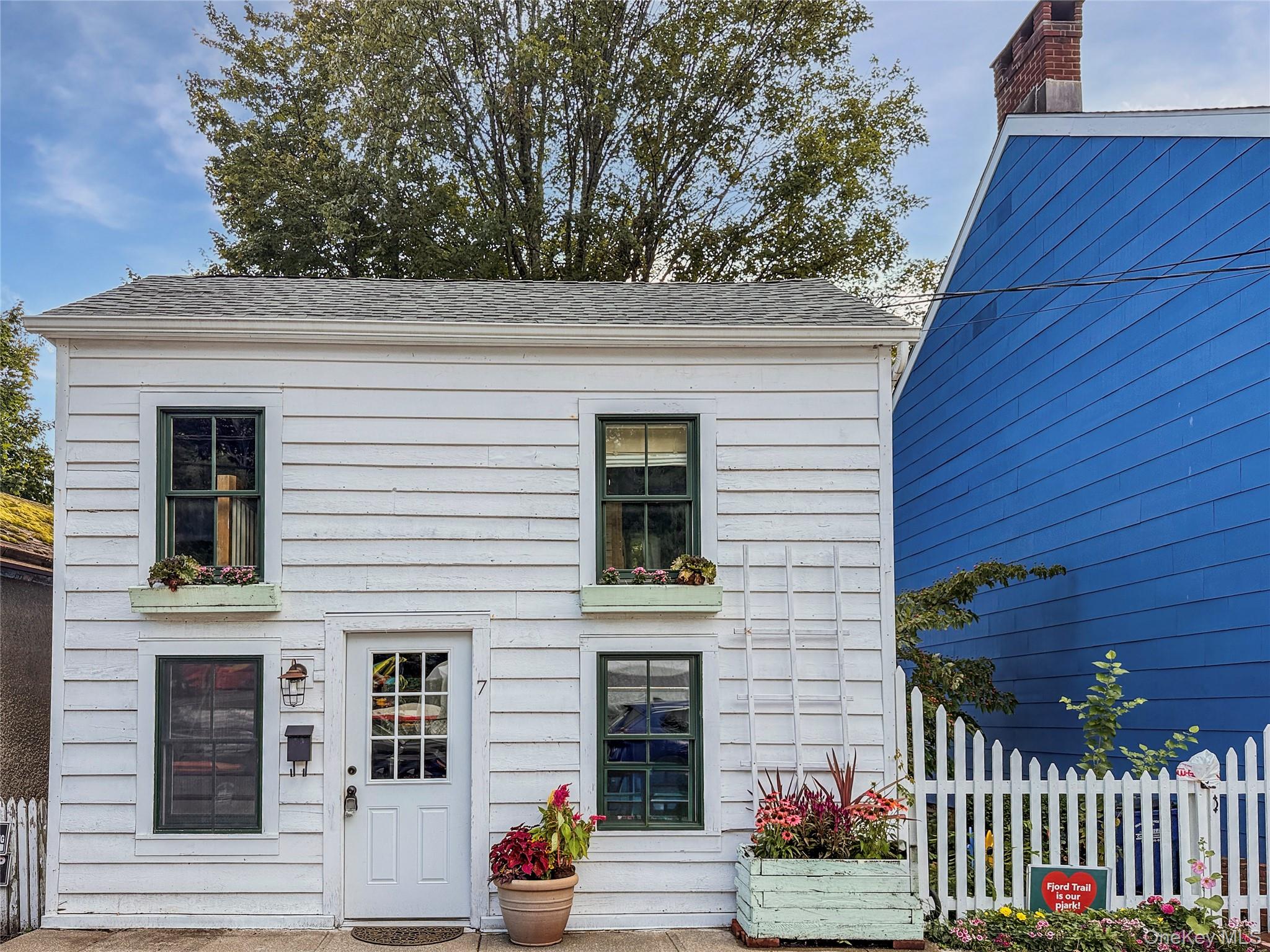 This 1860s Cold Spring Village cottage is brimming with heart. Steps from the riverfront, Main Street, schools, and Metro North, this home makes village living effortless. Step inside to a sunlit living space where every detail tells a story - exposed ceilings with knotty pine beams, reclaimed hardwood floors, charming shiplap pine walls and a warmth you can feel the moment you walk through the door. Smart design makes brilliant use of every inch of every inch of this cozy home. An open floor plan flows easily from the living and dining space to the kitchen, featuring convenient half bath, custom concrete counters and farm sink. On the second floor, the primary bedroom glows with sunlight behind French doors. An additional bedroom with open loft and cleverly situated full bath with claw-foot tub/shower & country sink complete this smart and seamless layout. Back porch and fenced, private back yard with reclaimed brick patio offers a low maintenance space to enjoy the outdoors. With it&rsquo;s blend of historic charm, walkable Village convenience and thoughtful design, this home is a rare opportunity - ideal for planting roots in Cold Spring Village or an easy low-maintenance weekend retreat just steps from the train