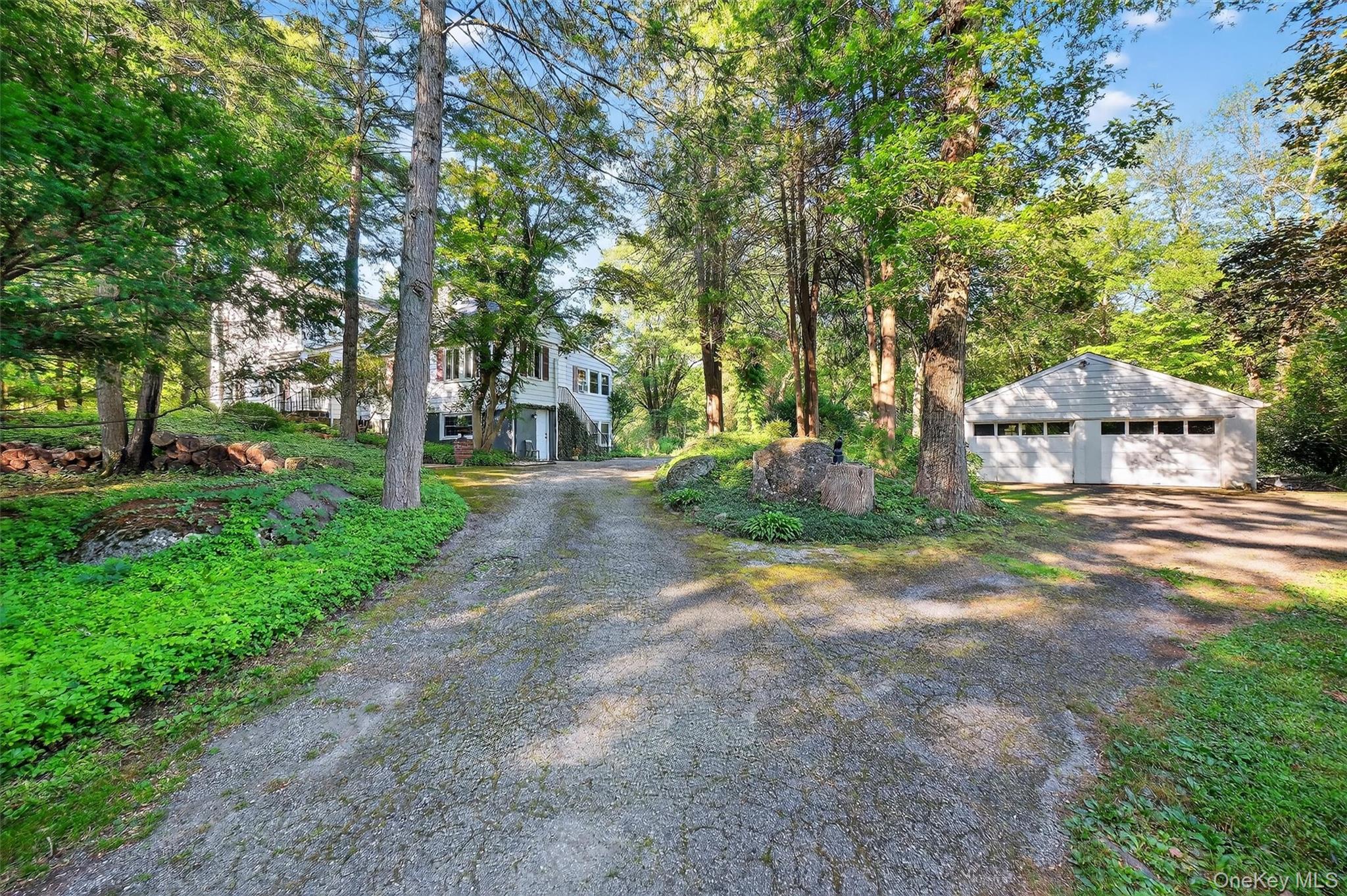Set in a park-like setting with gorgeous grounds, this home offers a rare combination of natural beauty and flexible living. Large windows fill the rooms with natural light and showcase woodland views as well as serene glimpses of the lake. Multi-level living creates a wonderful balance of privacy and flow, with the living room, dining room, and kitchen connecting seamlessly for everyday comfort and entertaining.The well-equipped kitchen enjoys views of the woods, while the dining room opens to a stone veranda perfect for gatherings. Additional highlights include a bluestone patio at the front entrance, a finished basement with wet bar, built-in bookshelves, and a wood-burning fireplace. First floor primary with full bath for added comfort. The detached two-car garage with workshop and a dedicated office space with private entrance on the garden level of home add both convenience and versatility.Outdoors, the property is equally special with a gardening room, private kayak launch, and Furnace Brook stream flowing nearby. In addition to private lake access, the community also offers shared access, and nearby hiking trails and the Town pool are only a short walk away. The floor plan provides plenty of space to create what works best for your lifestyleâ€”whether that means home offices, guest rooms, or hobby spaces.With its natural setting, thoughtful design, and endless amenities, this home offers a rare opportunity to enjoy comfort, privacy, and connection to the outdoorsâ€”all in one extraordinary property.