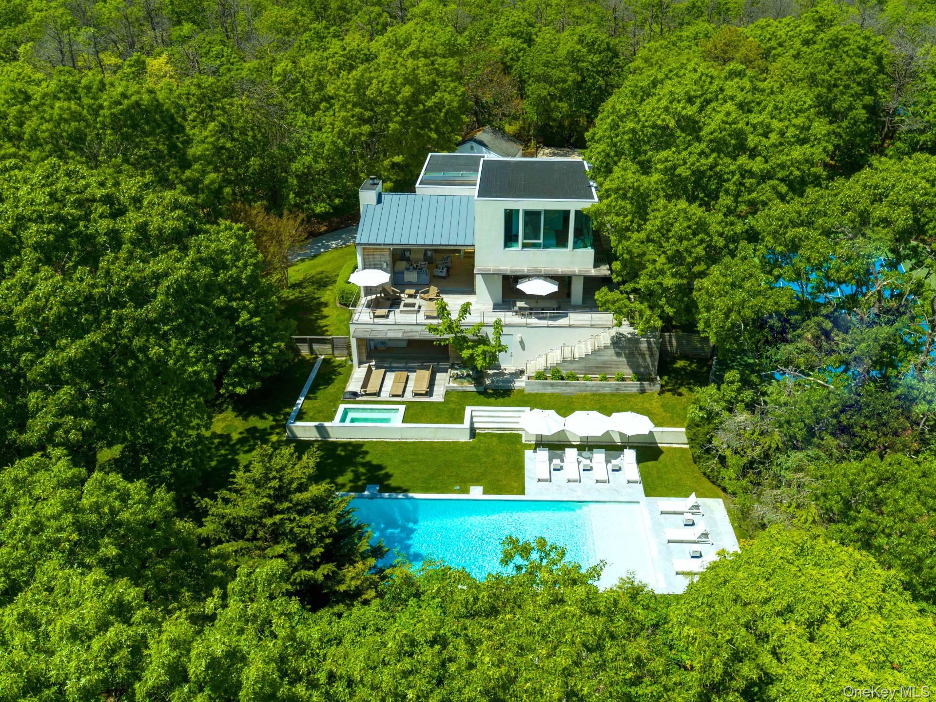 In a class by itself, New to Market, exquisite Malibu Style Modern Contemporary perfectly suited on a meticulously well-kept shy 2-acre parcel with Pool and Tennis offering the Ultimate in Hamptons Resort Style Summer living. Magnificently positioned and perched high above is where you&rsquo;ll find this exceptional Hamptons 4 level Modern bathing in full privacy and greenery with its commanding views of the full-sized North/South Tennis and its oversized 52x18 heated Saltwater Gunite Pool. Here summer never ends with its pool and jacuzzi wrapped in white marble and sprawling green lawns which take center stage all summer long. Boasting 6725 sqft of luxurious open and modern resort style living spaces on 4 levels which feature soaring ceiling heights, an abundance of natural light and its expansive sliding glass doors which magically blend the indoor and outdoor spaces effortlessly creating the ultimate Hamptons entertaining space. Guests of all ages will enjoy the well-appointed 4 Guest ensuite beds found on 2 private levels plus the additional private Owners Suite which occupies the entire 3rd floor, complete with Resort Style Spa bath and breathtaking views. For the discerning Chef, a fully outfitted Chefs Kitchen with its professional high-end stainless-steel appliances and large center island sit ready and waiting to deliver the ultimate dining experience while enjoying marvelous Tennis and Poolside views. A whole range of amenities are available on level 1 that enliven this unequaled Hamptons Summer Getaway, which include a Cinema room, Fitness center, sprawling lounge and its well-furnished wet bar. While serenity enwraps this captivating Hamptons retreat, it lies in superbly convenient proximity to world renowned Sag Harbor, Bridgehampton and Southampton shopping districts and its beloved Ocean Beaches.,