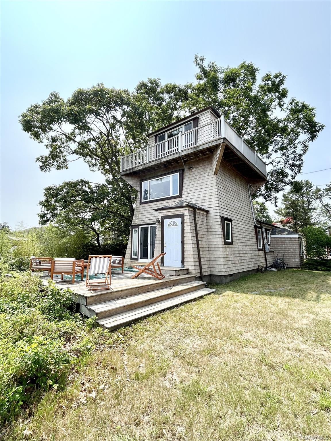 A spectacular location and a unique lighthouse style home, with 3 levels overlooking Shinnecock Bay in the premier bay-front community of East Quogue. Stylishly decorated and fully furnished, offering exquisite water views from numerous areas of the home. Features a ground-floor deck with sliding doors to the dining room and kitchen, a large picture window in the primary bedroom, and a wrap-around upper deck complete with breathtaking panoramic views from the 3rd floor great room which may be used as a 3rd bedroom or office. Spacious primary suite with walk-in closet, a generously sized living room with fireplace for entertaining, and an open kitchen/dining room concept. Offering full access to the large 2 car detached garage. The perfect waterfront getaway during any season!