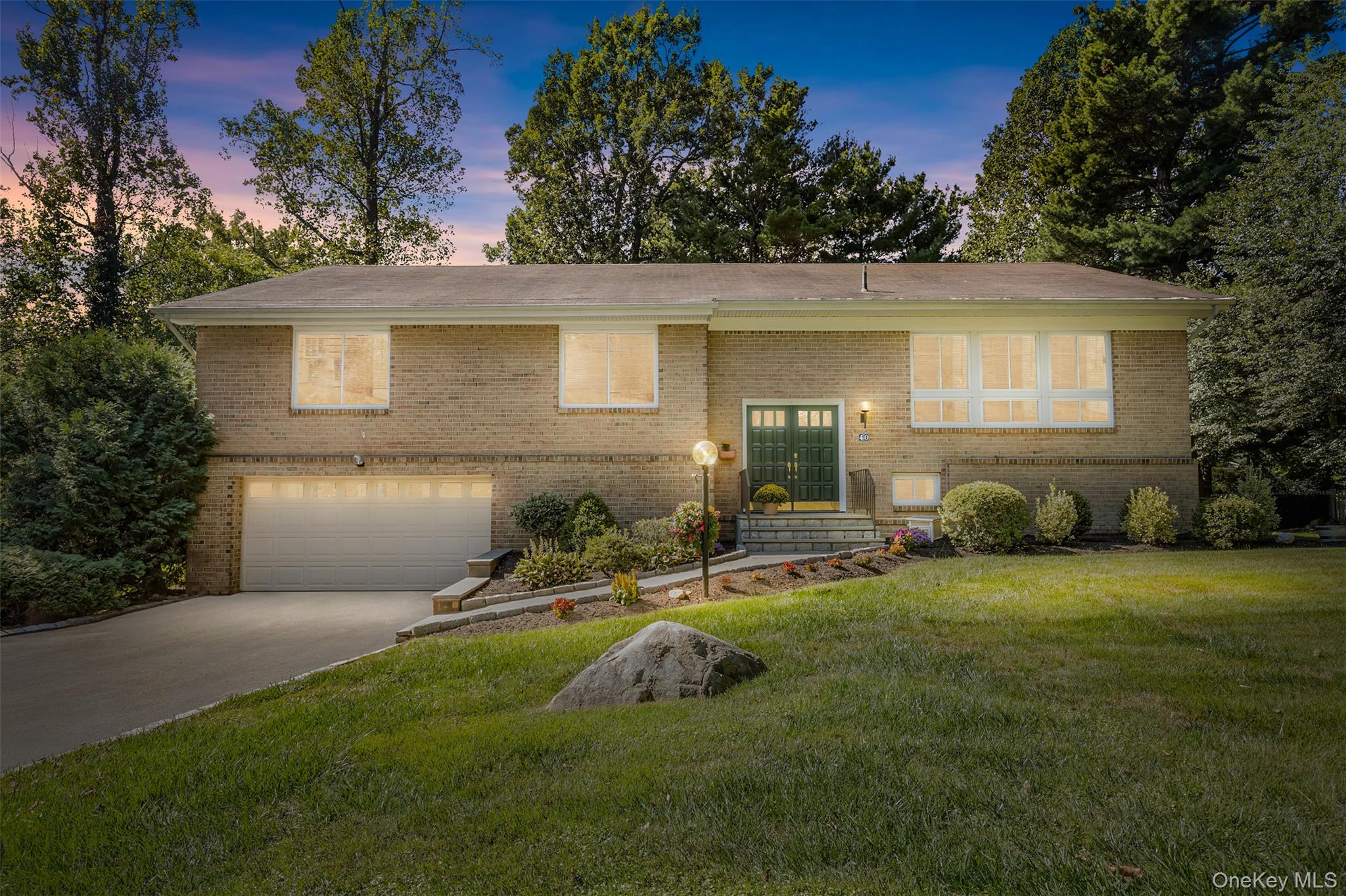 Gracefully nestled on nearly half an acre of lush, landscaped grounds, this distinguished light brick Raised Ranch exudes timeless appeal in the coveted, nationally recognized Edgemont School District. A grand first impression begins at the striking emerald green double doors, featuring raised panel detailing an eye-catching entrance that hints at the sophistication within. Natural light pours into the expansive living room through near floor-to-ceiling windows, creating an airy, uplifting space thatâ€™s perfect for both everyday comfort and stylish entertaining. Gleaming hardwood floors flow throughout, adding warmth and richness. Just steps away, the formal dining area sits beneath a dramatic vaulted ceiling with an elegant chandelier, ideal for hosting memorable dinners and celebrations. The updated kitchen is a true heart of the home, featuring brand-new stainless steel appliances, striking new laminate countertops and backsplash, and a cozy breakfast nook with sliding glass doors that open to the deck, your gateway to morning coffee or dining under the stars. Just off the kitchen, the main-level family room invites you to unwind in a space thatâ€™s both cozy and refined, complete with a charming wood-burning fireplace, a perfect backdrop for relaxed evenings or weekend gatherings. A full-size laundry room and abundant storage add effortless functionality to this beautifully designed main floor. The serene primary suite is a true retreat, featuring a dramatic navy-blue accent wall that adds a designer touch and creates a calming atmosphere. A spa-inspired ensuite bath makes mornings feel effortless and evenings feel indulgent. Three additional generously sized bedrooms offer flexibility for family, guests, or home office use, and are served by a beautifully appointed hall bath, blending style and practicality. Downstairs, the lower level extends the homeâ€™s versatility and comfort, offering the perfect setup for extended family, multi-generational living, or long-term guests. This thoughtfully designed space includes a sleek second kitchen with crisp white cabinetry, a bright dining or breakfast area, a spacious family room, a private bedroom, a full hall bath, and its own separate entrance. Direct access to the oversized two-car garage adds convenience, while a dedicated storage area and bath enhance functionality. Step outside and discover a true backyard sanctuary. The expansive, fully paved patio is ideal for effortless entertaining, with room for multiple dining areas, a BBQ station, and even a cozy firepit. A dedicated dog run offers a haven for your four-legged friend, while a separate playground area, garden shed, and sweeping lawn surrounded by mature landscaping create a peaceful and private outdoor escape. Perfectly located near top-rated Edgemont schools, luxury shopping, fine dining, major highways, and Metro-North, this beautifully upgraded home offers the ideal blend of elegance, comfort, and convenience in one of Westchesterâ€™s most desirable communities.