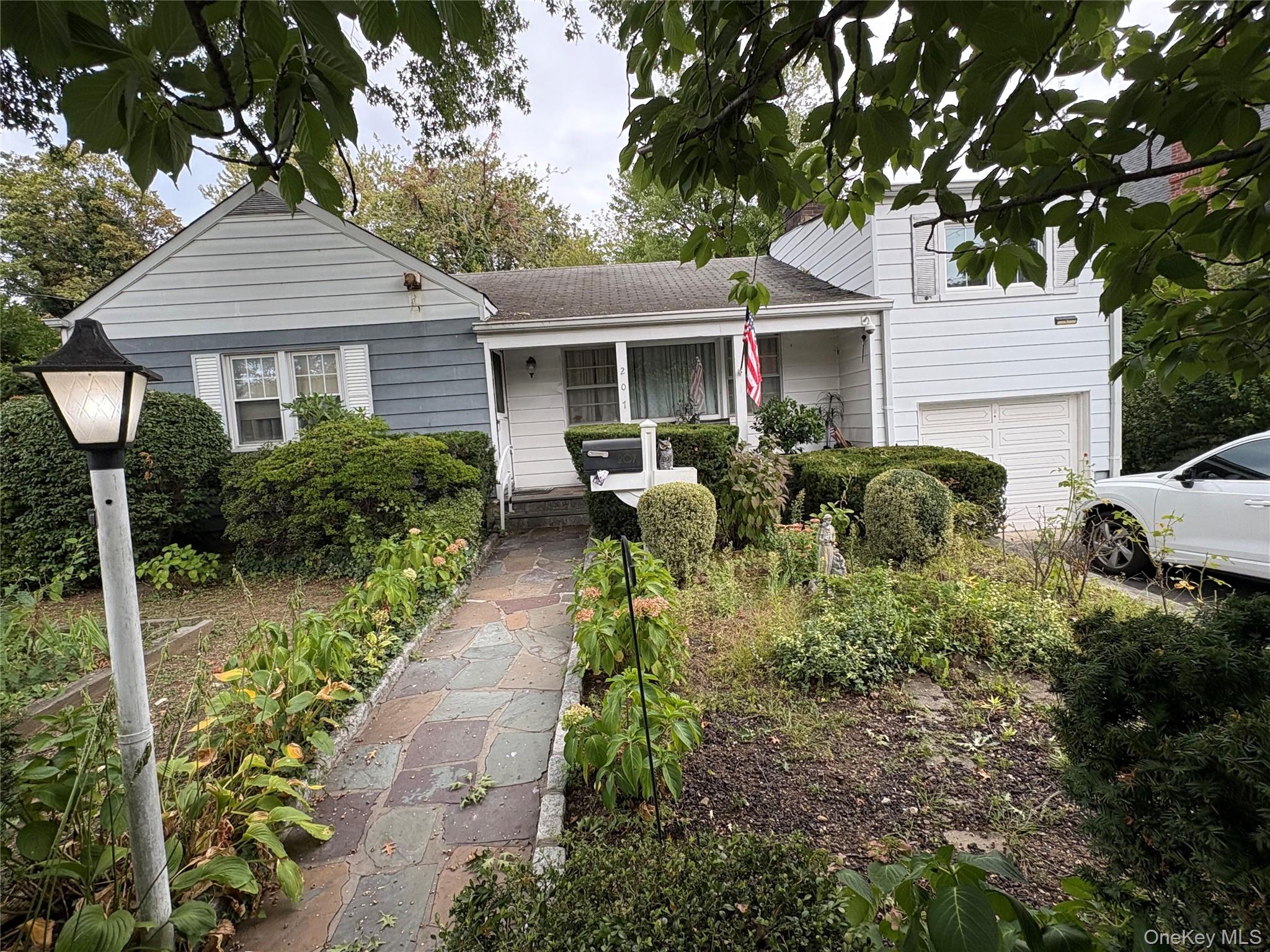 Location, Location Location. This home is situated on a quiet treelined street. Walk to metro north an NYC subways. Close to NYC. 2 minute drive to all major parkways. Walk to stores. 3 Beds, 2 Baths,  Large Living room with a brick fireplace. Finished basement with a wood burning stove. Fenced in back garden with a large patio. Hardwood floors Room for extended family