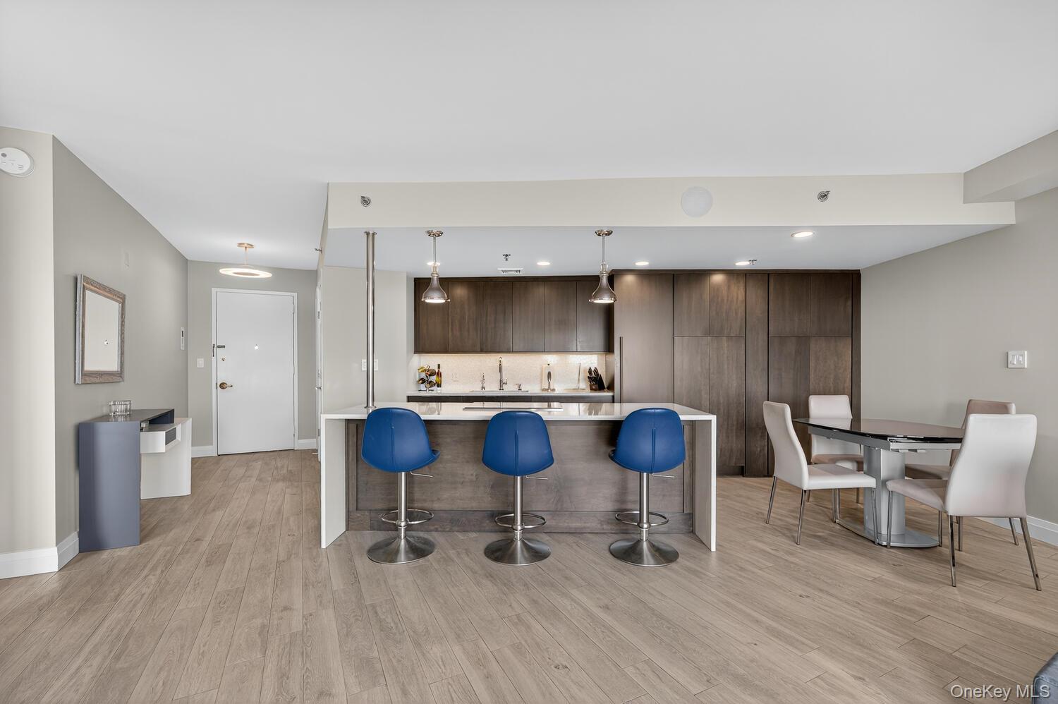 Welcome to the luxurious Wyndham East, offering 5-star, resort-style living with 24-hour concierge, doorman, and free valet parking. This sunny and bright upper-floor 1-bedroom, 1.5-bath residence has been custom designed with no expense spared. The open concept showcases porcelain tile floors and a designer kitchen with a waterfall quartz island and top-of-the-line appliances. The Sub-Zero refrigerator and dishwasher are paneled in custom cabinetry, seamlessly blending with the unitâ€™s elegant design.Perfect for both entertaining and relaxing, the layout offers sweeping views atop Garden City from every angle.The bedroom features custom built-in furniture and an extra-large walk-in closet. The primary spa bathroom includes double stone sinks, a two-person steam waterfall shower, and generous custom storage. Access the oversized terrace from both the living room and bedroom to enjoy the view.Alexa-enabled lighting and a surround sound system elevate the experience. A walk-in pantry with washer, dryer, and additional storage sits off the kitchen, along with a conveniently located half bath. A double closet in the entry hall completes the ideal layout for luxurious, effortless living.Amenities of the Wyndham include heated Pool, jacuzzi, gym, sauna, party room and business center. On beautifully landscaped grounds with pond and walking paths, outdoor grill, dedicated large storage unit and valet parking for one spot with options for 2nd. Conveniently located in the heart of Garden City near stores, restaurants & the LIRR.