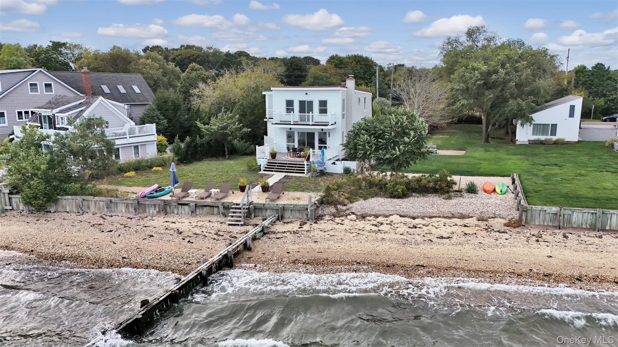 Welcome Home to 12960 Main Road, a Rare Bayfront, Beachfront Beauty! This (3) Bedroom, (3) Bath Residence is fully-updated, light and bright, and features a desirable open floor plan, with windows and sliders throughout, offering panoramic views of Gardiner&rsquo;s Bay and Bug Light. As you enter the foyer leading to the stunning Chef&rsquo;s Kitchen and Living Room, you will be captivated by the wall of windows and glass sliders showcasing the vast Blue Bay and Blue Sky, and you will be hooked! The Living Room also has an attractive electric fireplace, adding ambiance and warmth on those cooler days of the year. As they say in Real-Estate, Location, Location, Location! and this is one that can&rsquo;t be beat, as you and your family and friends will feel so relaxed and rejuvenated in this serene coastal environment, that you won&rsquo;t want to leave! There is a first floor Den with glass sliders, a balcony, and a waterview which may serve as a possible 4th Bedroom. There is also a Full Bath, Laundry area, Storage and Utility Room on the First Floor. Upstairs, you will find the Primary Suite, complete with sliders and a balcony, ideal for enjoying sunrises and sunsets, while viewing the plentiful boaters, kayakers and paddleboarders on the open water! One of the other two Guest Bedrooms upstairs features glass sliders with a balcony, as well as an adjacent Bonus Room, which may serve as a wonderful children&rsquo;s playroom or office. The 3rd Full Bath is also located on the Second Floor. This Residence is made for entertaining, sporting a large trex deck off the Living Room and overlooking the Bay, where so many meals and festivities may be enjoyed, as well as offering private Beachfront, a mooring and bulkheading. Room for an inground, waterfront pool enhances the appeal of this property, as does its private gated entrance and finished shed with electric, which may serve as a future pool house. And, for additional activities and options, the Village of Greenport is only a short distance away, offering a vast array of Art Galleries, Museums, Fishing Charters, Golf, Boutique Shops, Breweries and Cideries, Waterfront Dining and other Entertainment Venues. Simply stated, here you may enjoy a lifestyle second-to-none, and one which you so richly deserve!