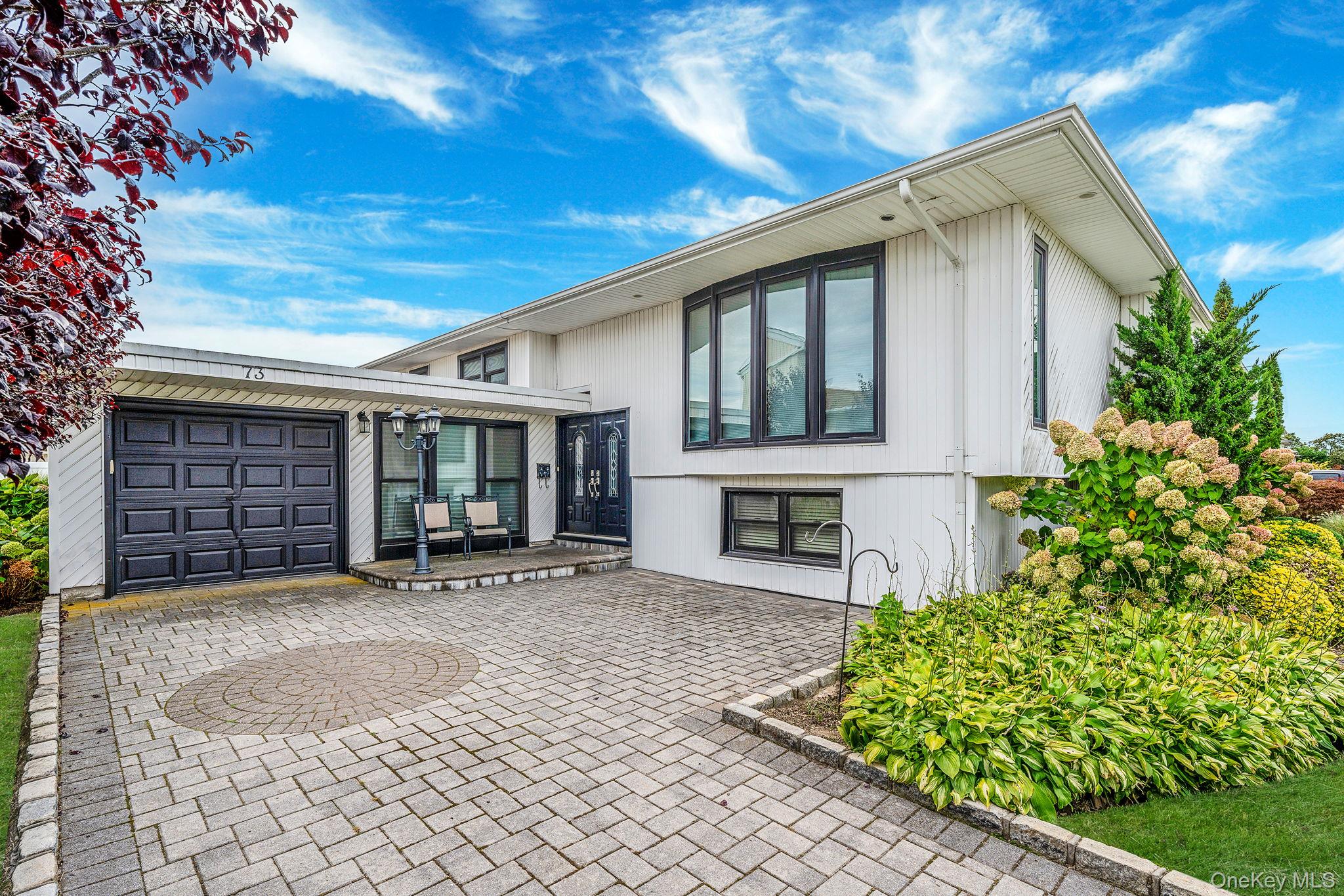 Welcome to this spacious 4-bedroom, 2-bath Hi-Ranch, perfectly designed for comfort and convenience. The main level features an updated kitchen with premium stainless steel appliances, including a Wolf stove, along with bright and inviting living spaces. The lower level offers a fully equipped summer kitchen and direct access to a lanai, creating the ideal setup for entertaining. Enjoy the beautifully finished exterior with pavers throughout the driveway and backyard. Located just minutes from Long Beach Road, youâ€™ll be close to shopping centers, local shops, restaurants, and more.