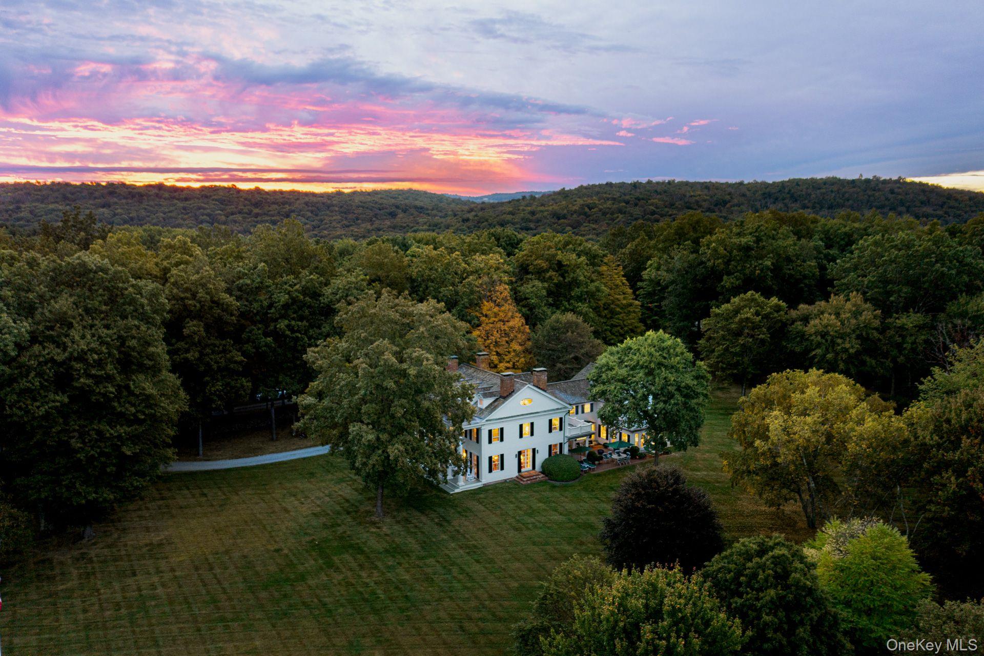 Linley House Estate â€“ A Once-in-a-Generation Hudson Valley Opportunity. Perhaps only once in a generation does such a rare opportunity arise to acquire one of the most private, historically significant, and visually commanding estates in the heart of the Hudson Valley. Welcome to The Linley House Estate, an extraordinary Greek Revival Center Hall Colonial set on over 113 pastoral acres across three parcels, with additional land available for the discerning buyer.This iconic Civil War-era home stands as a crown jewel among Hudson Valley estatesâ€”gracious, timeless, and exquisitely sited to capture sweeping views of the Catskills and the Hudson Valley. With newly cleared view sites and meandering trails, the property opens to a world of natural dynamism, making it uniquely suited for a multi-generational compound or a private retreat of exceptional caliber.The estate residence features 8 bedrooms and 10 bathrooms, with grandly proportioned public rooms, soaring ceiling heights, and cozy, intimate spaces that invite relaxation and gathering. The chefâ€™s kitchen, open to a warm and inviting family room with a wood-burning fireplace, is perfect for daily living and entertaining alike. French doors lead to a wide veranda ideal for alfresco dining and sunset views.The primary suite offers a true retreat with its own fireplace, two walk-in closets, and dual en-suite baths. The second floor includes four additional bedrooms, multiple bathrooms, and a private guest seating area. South-facing rooms enjoy access to private terraces with breathtaking views. The third floor boasts two more guest rooms, each with en-suite baths.The property is designed for recreation and entertainment on every level:â€¢ Heated Gunite poolâ€¢ Tennis and basketball courtsâ€¢ Fitness centerâ€¢ 16-seat movie theater with concession standâ€¢ Rustic yet elegant party barn. Ideally located in the heart of the Millbrook Hunt Country, just 90 minutes from New York City and minutes from the charming village of Millbrook, the Linley House Estate offers a rare blend of historic prestige, natural beauty, and modern lifestyle.