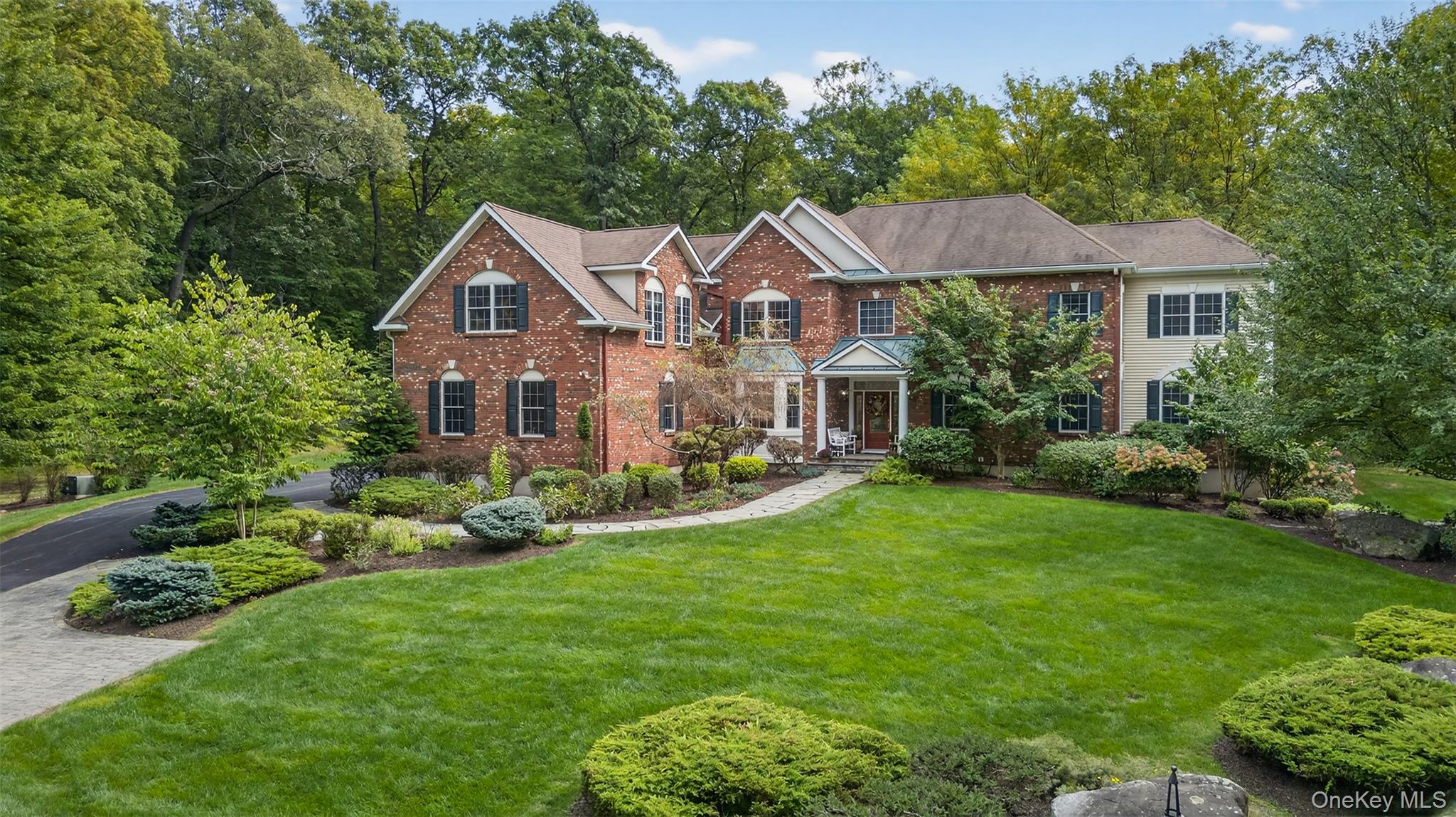 Nestled in one of Cornwallâ€™s most sought-after cul-de-sacs, Chadeayne Woods, this stately brick colonial offers nearly 6, 000 square feet of luxurious living space and the perfect combination of privacy, craftsmanship and elegance. Tucked behind a gated entry, a quarter-mile paved driveway winds through 26 park-like acres to your own peaceful retreat. Cleared paths invite you to explore, while three fenced acres surrounding the home provide plenty of room to roam. This one-owner home was custom built, professionally decorated and inspired by a love of entertaining with ample space for guests - both inside and out! The open floor plan blends formal and functional spaces beautifully while remaining uniquely comfortable and inviting. Hardwood floors run throughout the main level and exquisite millwork - including stained glass transoms and French doors - accent the living and dining rooms opening to a music room/study. The two-story family room is anchored by a striking stone fireplace flowing seamlessly into a stunning sunroom, out to a party deck and down to a slate patio overlooking the large, level backyard. At the heart of the home, the chefâ€™s kitchen impresses with rich wood cabinetry, stainless steel appliances including a Viking cooktop with pot filler, unique mosaic tile backsplash, cooling drawers, double oven, wine refrigerator, a quartz-topped center island and two walk-in pantries. A first-floor study with a full bath offers a comfortable work-from-home option. Upstairs, the massive primary suite wing is a true standout, providing a peaceful sanctuary with a cozy window seat, built-in bookshelves and a private sitting room. The spa-inspired bathroom features dual sinks with custom cabinetry, a stylish tiled shower and an oversized cast iron tub. A jaw-dropping custom walk-in closet, filled with natural light from a wall of windows, is unmatched. Down the hall youâ€™ll find another ensuite bedroom and a guest wing with two additional spacious bedrooms and full bathroom. The finished walkout basement boasts the fifth full bathroom and a three-car garage, custom built shed and spacious mudroom/laundry off the driveway are just more highlights of this exceptional property. Experience it all in a tranquil, storybook setting within the Cornwall school district - complete with natural gas, municipal water and an ideal commuter location just minutes to highways, train, bus, village amenities, restaurants and all the best of Hudson Valley living.