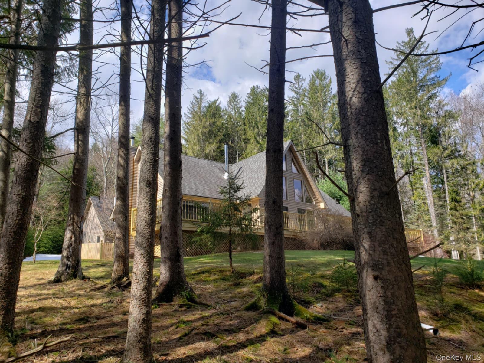Beautifully Chic Contemporary Chalet in the gated community of Oxford Estates with exclusive access to pristine Black Lake! This custom-built home is just what the doctor ordered for a peaceful, quiet lake life, surrounded by nature with a minimalist vibe. Upon entry, you are greeted with soaring cedar-lined ceilings and a wall of Canadian peach sliders that bring the outside in, reminding you that you are in relaxation mode! The kitchen is just right, with granite countertops, a center island, custom-made cherry cabinets, and a pull-out pantry that will soon become your favorite accessory! The living room is the center of the home with a cozy and delightful woodstove and beautiful hardwood flooring. There are two bedrooms on the main floor, at opposite ends of the home. The primary bedroom is complete with a walk-in closet, a full remodeled bath, a marble vanity, high-end fixtures, and a tub with a tempered glass enclosure. The bedroom sliders lead to the jacuzzi and deck that may easily become a morning or evening ritual! The second bedroom and a full remodeled bath are located on the other side of the living room, featuring a cedar accent wall. Walk upstairs for an additional two rooms and a fabulous loft that showcases the chalet element of this home, perfect for a yoga studio, reading spot, office or playroom. Need more space? There is a full, immaculate basement which houses the utilities and oil tanks. Another thoughtful feature is the cedar fence surrounding the home, perfect for your 2 or 4-legged children. In addition, thereâ€™s a lofted two-car garage and an Amish-made Garden/hobby shed nestled in the trees at the back of the property. Beautifully landscaped and complete with a fruit-yielding apple tree! Black Lake is a 200-acre private non-motor-boating lake preserve that focuses on maintaining the high quality and purity of the water and its surrounding land. Enjoy great fishing from your pontoon, sail, or kayak, just a short 2-minute walk from the home. This paradise is just minutes to Bethel Woods Center for the Arts and a short drive to shopping, eateries and services, including The Forestburg Playhouse,  Eldred Preserve, Resorts World Casino and Kartrite Resort and Waterpark. HOA includes the maintenance of communal spaces and roads, as well as snow plowing during the winter months. Maintenance and setup of the dock by the lake, mooring space for the boat from mid May through Oct.31. The beach area and docks were all redone a couple of years ago.