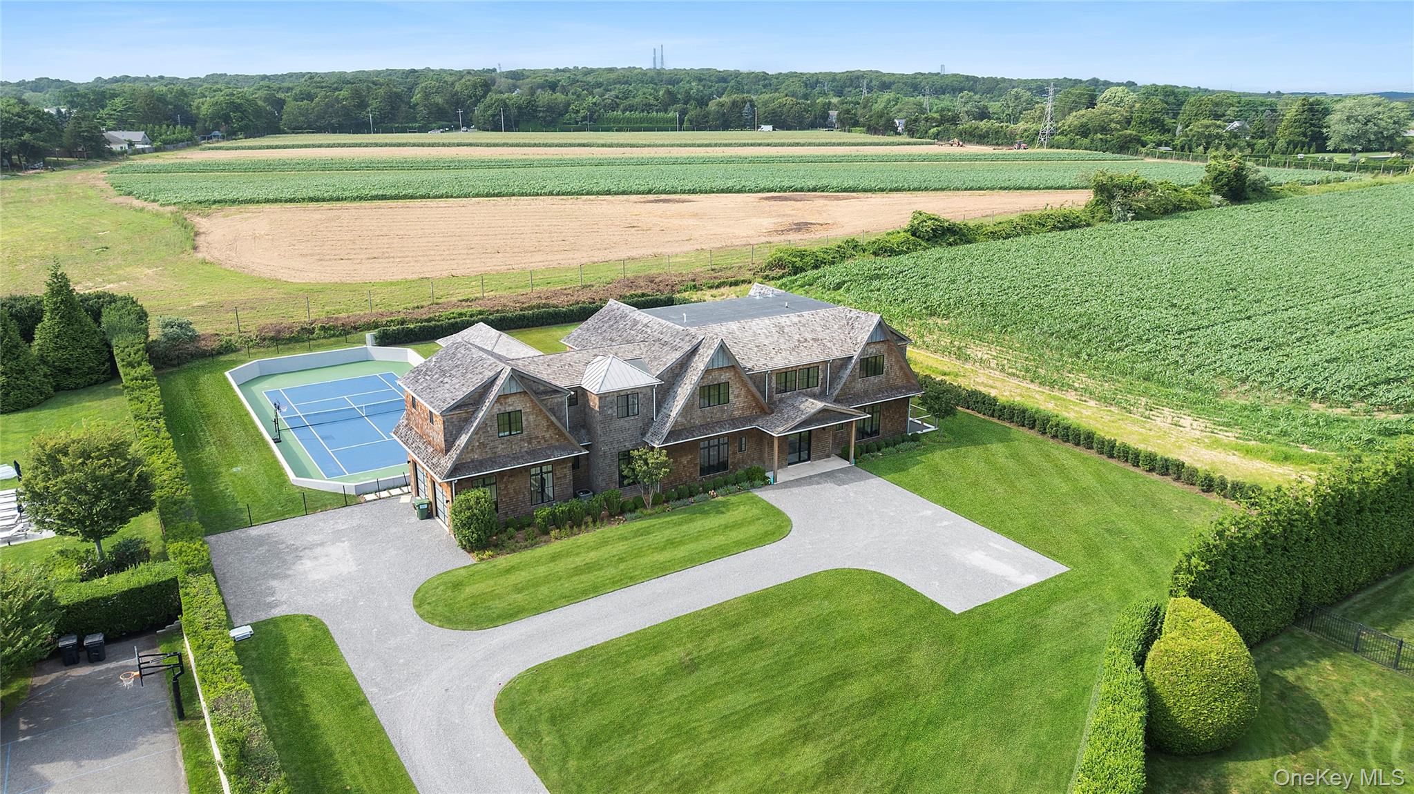 Tucked away at the end of a quiet cul-de-sac in the heart of Southampton, 58 Clearview Farm Road unveils a brand-new transitional-style estate that epitomizes modern Hamptons luxury. Just completed in 2025 and nestled on 1.07 beautifully manicured acres overlooking a tranquil agricultural reserve, this 8-bedroom, 9 full and 2 half-bathroom masterpiece spans 8, 733 square feet of thoughtfully designed living space across three sunlit levelsâ€”all with soaring ceilings and walls of glass that welcome in the natural light and pastoral beauty from every angle.As you enter through the front doors, you&rsquo;re greeted by a breathtaking open floor plan that effortlessly blends volume, light, and flow. The great room stuns with its double-height ceilings and massive black-framed windows that showcase uninterrupted views of the lawn, pool, and rolling fields beyond. Anchored by a sleek linear fireplace and rich wood paneling, the space connects seamlessly to the show-stopping chefâ€™s kitchenâ€”where custom white oak cabinetry, integrated appliances, a large center island, and a dedicated dining area set the tone for elegant entertaining and everyday ease.The bedroom layout offers ultimate flexibility and privacy: a luxurious junior primary suite sits on the first floor, five additional bedrooms (including the grand primary suite with a spa-like bath and private terrace) are located upstairs, and two more guest rooms rest in the walk-out lower levelâ€”perfect for hosting extended family or live-in staff. Every bathroom is beautifully appointed, while each bedroom enjoys serene views and bespoke finishes.Outside, a resort-style backyard awaits: a brand-new 18x48 heated gunite pool with spa, sun shelf, and adjoining pool house sit front and center, framed by lush green lawn and tall perimeter hedging for total privacy. Just beyond, a professionally finished tennis court offers yet another level of luxury living, while an attached 2-car garage adds everyday convenience.The fully finished lower level includes a state-of-the-art gym and spacious lounge area, all opening to the backyard through full-height sliders, making indoor-outdoor living a reality on all three levels. With high ceilings throughout and every amenity curated for a sophisticated lifestyle, this home is both a peaceful retreat and a Hamptons entertainerâ€™s dream.Located just moments from Southampton Villageâ€™s world-class shops, restaurants, and ocean beaches, 58 Clearview Farm Road is that rare offering: newly built, supremely private, elegantly designed, and set against the backdrop of preserved farmlandâ€”a forever feeling of space, light, and nature.