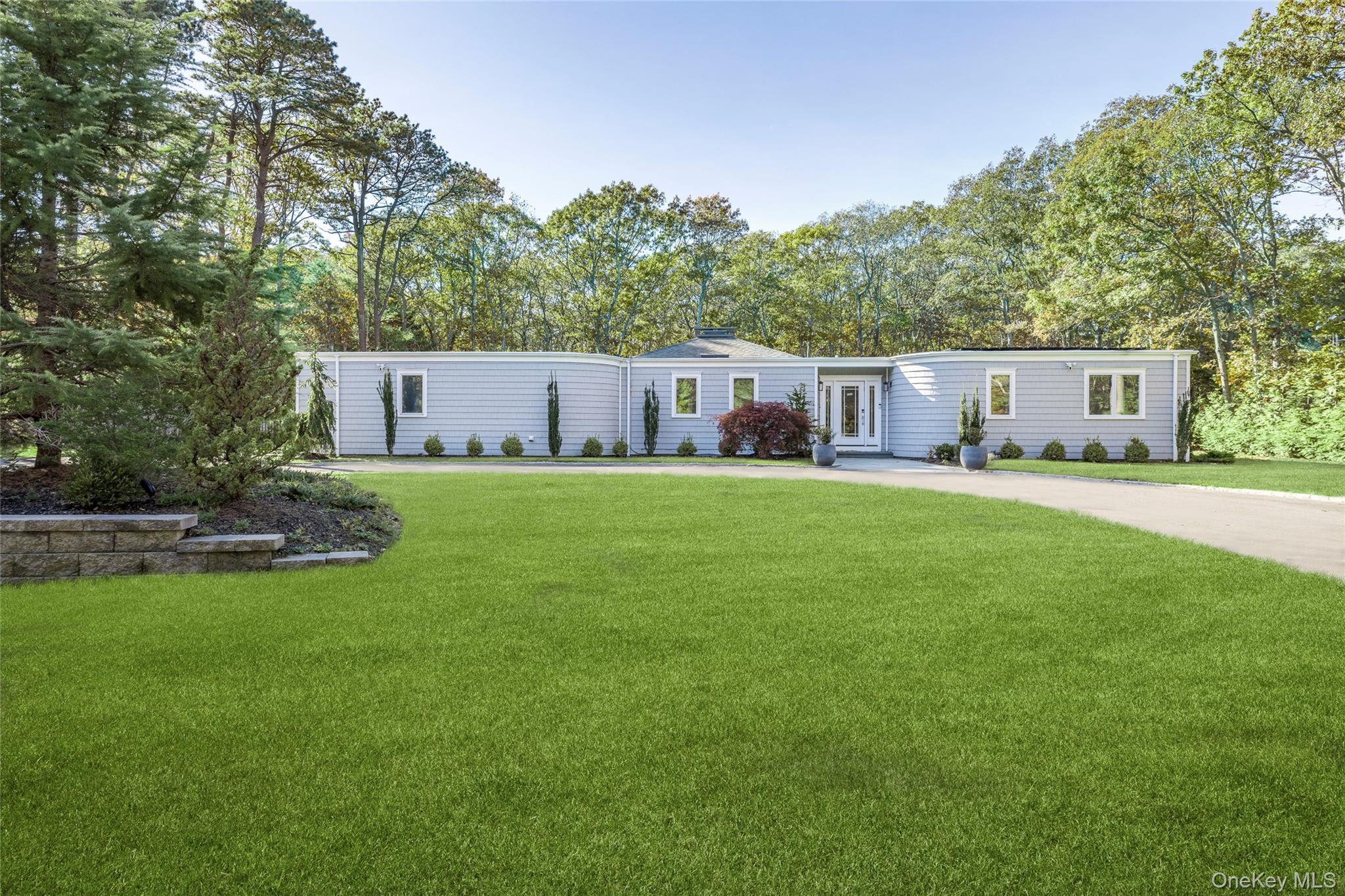 Set on immaculately landscaped grounds, this beautifully appointed contemporary home exudes an idyllic coastal lifestyle, seamlessly blending indoor and outdoor living with elegance and comfort.The open concept living space is vast and offers a spacious and newly renovated island kitchen equipped with Quartz countertops, ample cabinetry and stainless-steel appliances for the culinary enthusiast. The dining and living areas feature vaulted ceilings, a wood burning fireplace and sliding glass doors bringing in an abundance of natural light and providing easy rear yard access. Off the living room, an oversized guest bedroom boasts large windows and sliding glass doors inviting the lush greenery in. On the opposite wing, the expansive primary bedroom boasts a newly renovated en-suite bath, a large walk-in closet as well as direct pool access. Off the hall there are two additional generously sized bedrooms, a third fully renovated full bath and additional storage. Outdoors, the fully fenced yard is a private oasis. Relax in the new heated in-ground pool, dine al-fresco or entertain on the expansive deck. Mature and manicured landscaping surrounds the property creating a secluded and serene atmosphere. Other amenities include solar panels, a full-service mud/laundry room, an attached one-car garage and a full basement. This home is conveniently located just a short drive to some of the most beautiful ocean and bay beaches, sought after waterfront restaurants and is centrally located to both Southampton and Westhampton Beach Villages. A must see!