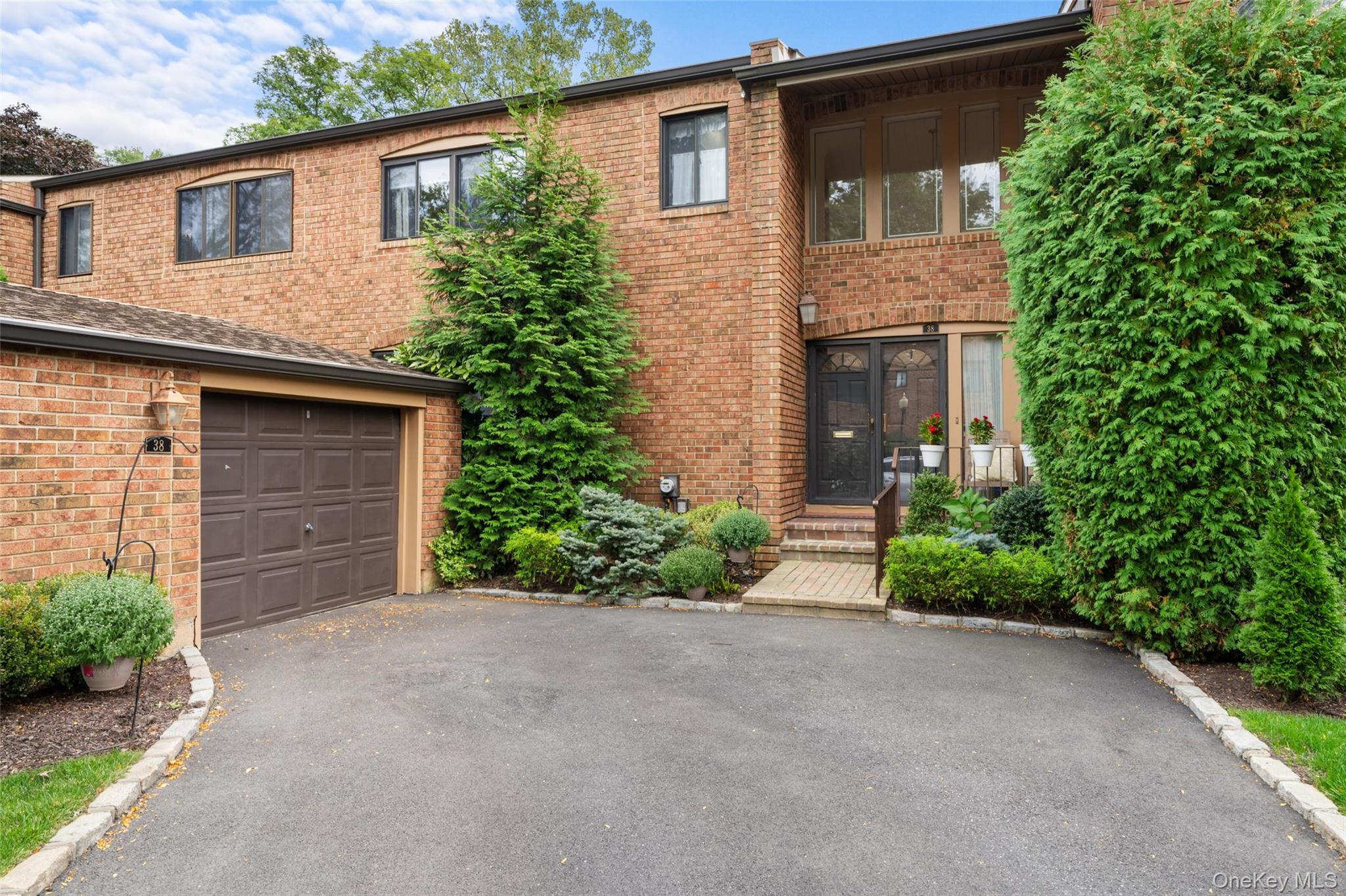 Welcome to The Gates at North Hills â€“ Where Luxury Meets ConvenienceNestled in one of the most desirable communities in the area, this beautifully maintained condo townhouse offers the ideal combination of comfort, space, and modern living. Located in the Great Neck South School District, this spacious home features 3 bedrooms, 2.5 bathrooms, and a fully finished basement with an open staircase that enhances the homeâ€™s airy feel.Step through a rare double-door entry into a sunlit foyer with soaring 18-foot cathedral ceilings â€“ a grand and welcoming first impression. The living room is warm and inviting with a wood-burning fireplace and gleaming hardwood floors. The kitchen is equipped with granite countertops and an eat-in-kitchen, while the formal dining room is perfect for hosting gatherings.The generous primary suite offers a true retreat, complete with an ensuite bathroom featuring a whirlpool tub, expansive walk-in closets, and custom built-ins. Enjoy outdoor living with both a front porch and a very expansive rear deck, perfect for relaxing or entertaining.This south-facing unit overlooks a tranquil pond and is conveniently located near major highways, public transportation, top hospitals, and an array of shopping, dining, and entertainment options.Low taxes and common charges cover snow removal, landscaping, pool, tennis courts, and video security â€“ making for stress-free living. This home can also be sold furnished for added convenience, at an additional cost.