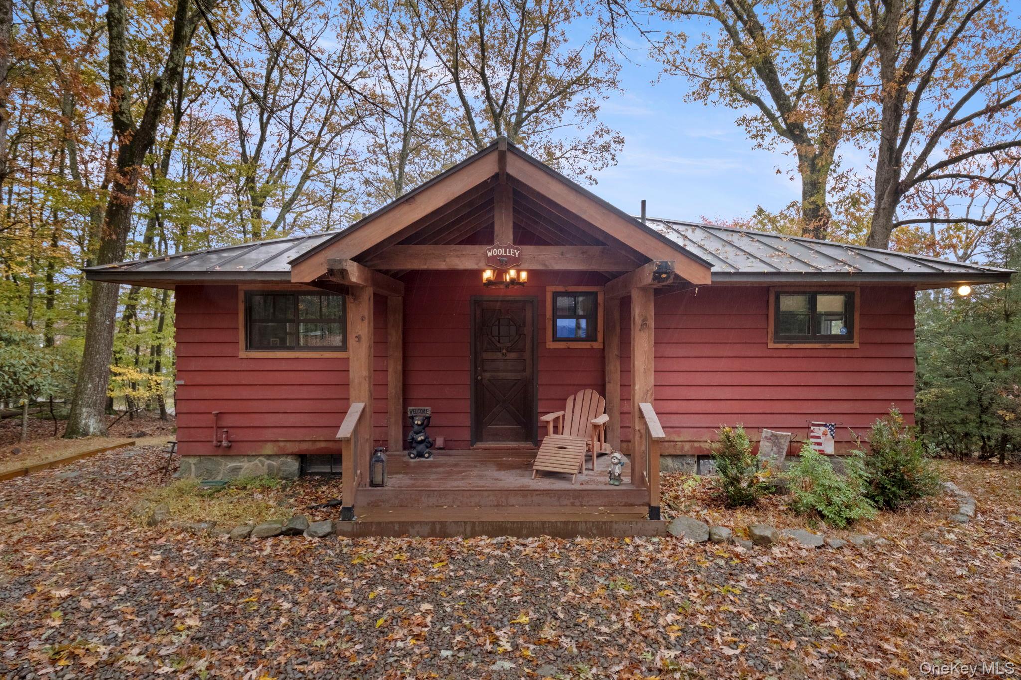 This fully renovated Wolf Lake retreat sits just steps from the water, with direct adjacent lake access shared by only one other home; no road to cross, and as close to lakefront as you can get without being on the shoreline itself. Across the road, enjoy hundreds of acres of forever-wild Wolf Lake member-owned lands for hiking, hunting, and camping.This lake-home blends classic Catskill warmth with modern comfort. The interior features an open kitchen with stainless steel appliances, a farmhouse sink, and new cabinetry, while exposed beams and natural wood finishes carry throughout the open-concept living and dining areas.Enjoy the glow of two fireplaces; one in the main living room and another in the lower-level bonus room currently used as a guest suite. The property also includes both an attached walkout garage and a detached garage by the road, providing abundant storage for boats, ATVs, or a workshop.With a metal roof, updated systems, and private access to one of Sullivan Countyâ€™s most desirable lake communities, this property offers year-round comfort and lake living at its best.Wolf Lake is one of Sullivan Countyâ€™s most sought-after private lake communities, featuring 1, 800 acres of preserved forestland, miles of maintained trails, and member access to three spring-fed lakes. The clubhouse hosts a full calendar of community events, all just 90 minutes from the George Washington Bridge.One-time Wolf Lake membership fee: $5, 250. Annual dues: $1, 200.