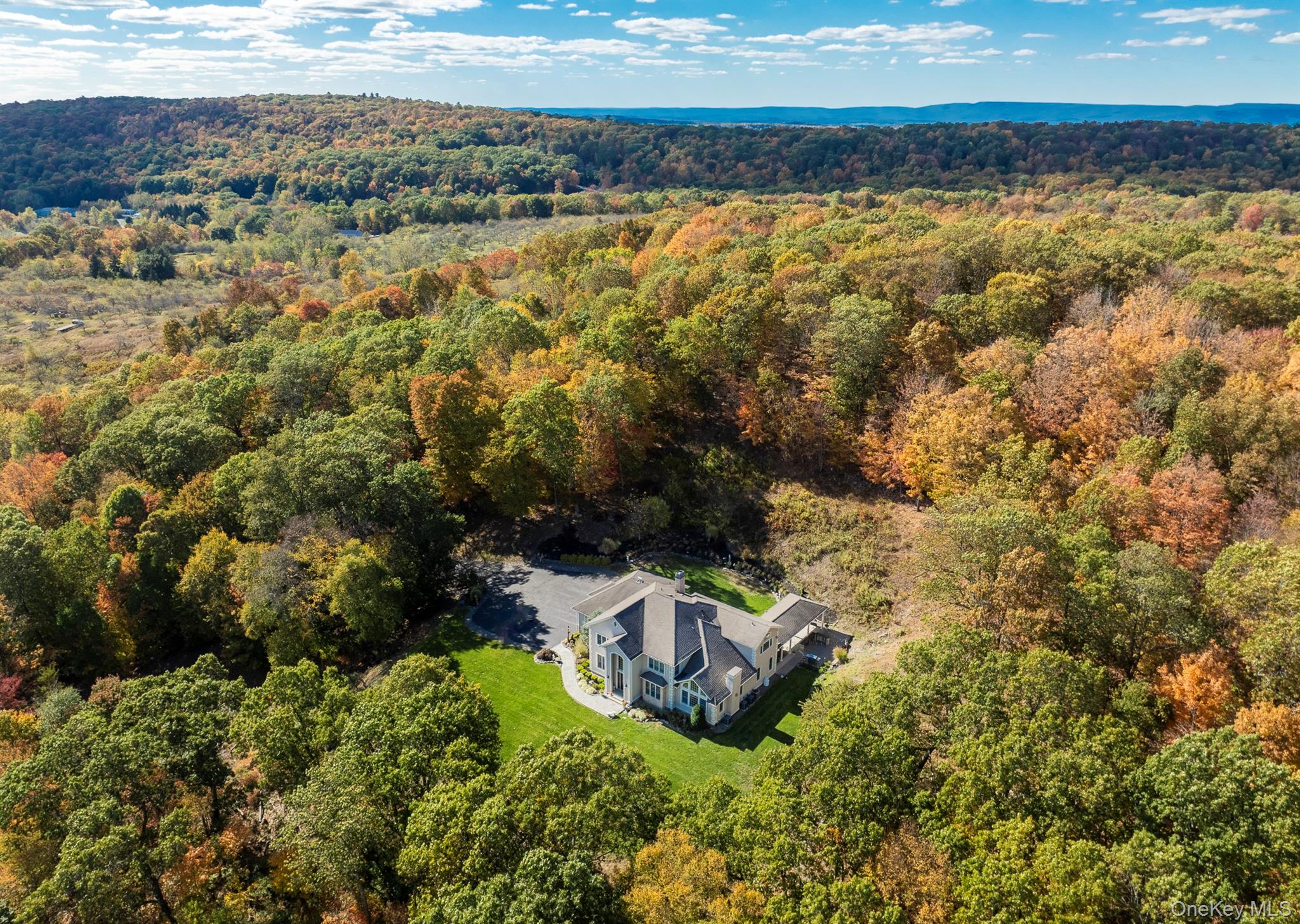 A Hudson Valley Estate of Quiet Grandeur and Stunning Views. Perched amidst nearly twelve acres of private orchard and rolling hillside, this 5, 072-square-foot residence in Marlboro, New York, is a modern Hudson Valley sanctuaryâ€”crafted for those who seek beauty, privacy, and an effortless connection to nature. A long, tree-lined drive winds toward the 2007 architectural masterpiece, revealing landscaped gardens and a three-car heated garage with tiled floors. Beyond the stately entrance, the interiors unfold in a sequence of light, volume, and elegance: coffered, vaulted, and tray ceilings interplay with oak and tile flooring, creating an atmosphere that is both refined and inviting.Designed for entertaining, the open floor plan gracefully connects formal and informal living spaces. A grand dining roomâ€”bathed in natural lightâ€”sets the stage for intimate dinners, while the adjoining living room, anchored by a fireplace and framed by sweeping Hudson Valley views, becomes the heart of the home. A built-in bar and entertainment room invite convivial evenings that flow seamlessly between indoors and out. The newly reimagined kitchen blends sleek modern design with professional-grade function. A Wolf range and Sub-Zero refrigerator serve as centerpieces within a space defined by clean lines, custom cabinetry, and a sunlit breakfast nook that overlooks the landscaped backyard â€”a perfect setting for morning coffee or casual meals. Upstairs, the primary suite serves as a personal retreatâ€”a tranquil escape with a spa-inspired bath, walk-in closet, and views that shift with the seasons. Three additional ensuite bedrooms, each with walk-in closets, ensure comfort and privacy, while a thoughtfully placed laundry room adds convenience. Outdoors, expansive patios and open lawns invite gatherings beneath the wide Hudson Valley sky. Whether hosting al fresco dinners at sunset or wandering through the orchard at dawn, this estate embodies the elevated luxury of country livingâ€”just moments from Marlboroâ€™s vineyards, markets, and scenic trails.Perfectly situated for both serenity and connection, the property is just 10 miles to the Metro-North/Amtrak station in Beacon and approximately 75 miles to Manhattanâ€”making it an ideal Hudson Valley retreat within easy reach of the city.