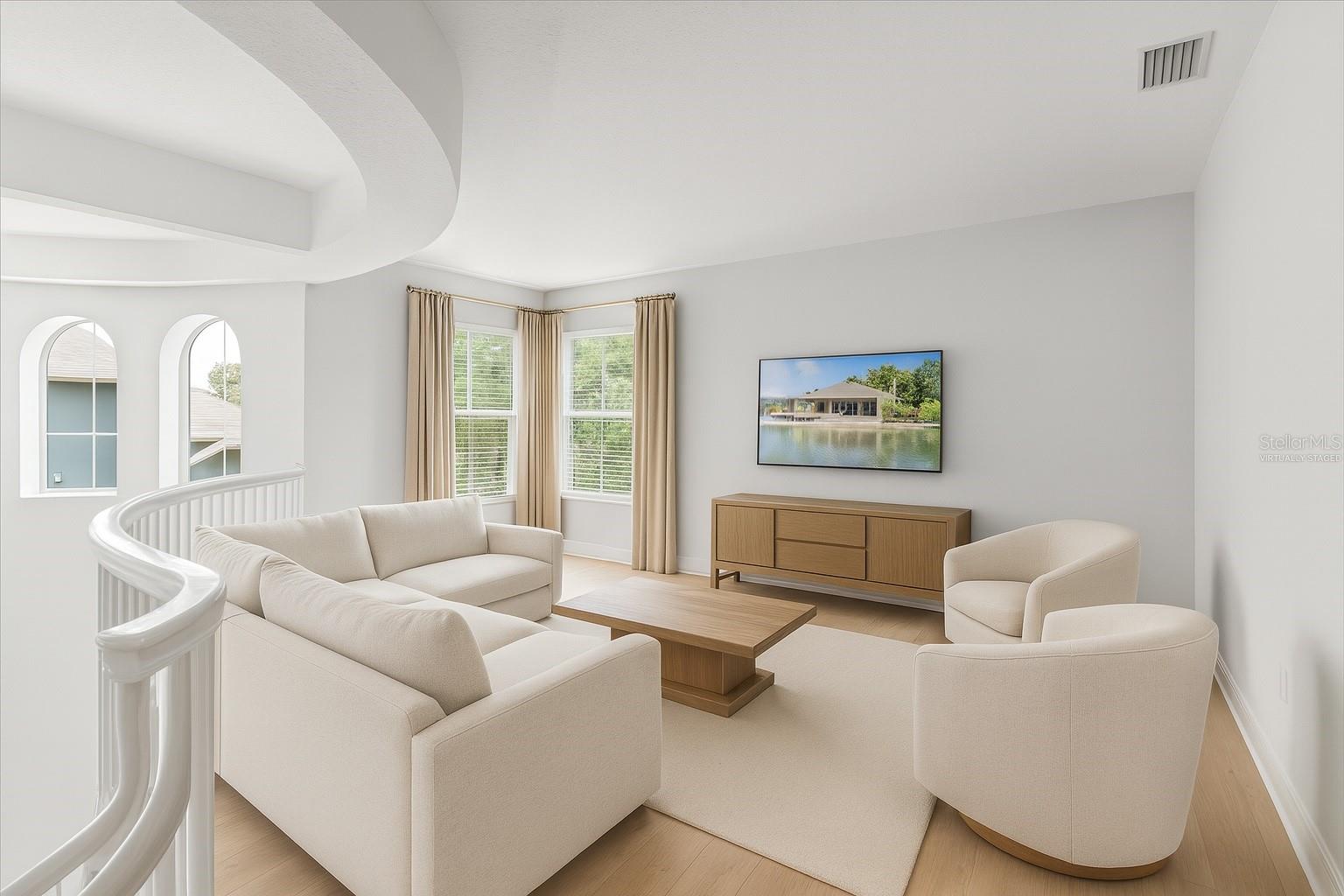 2nd floor loft living room space off sweeping staircase and virtually staged