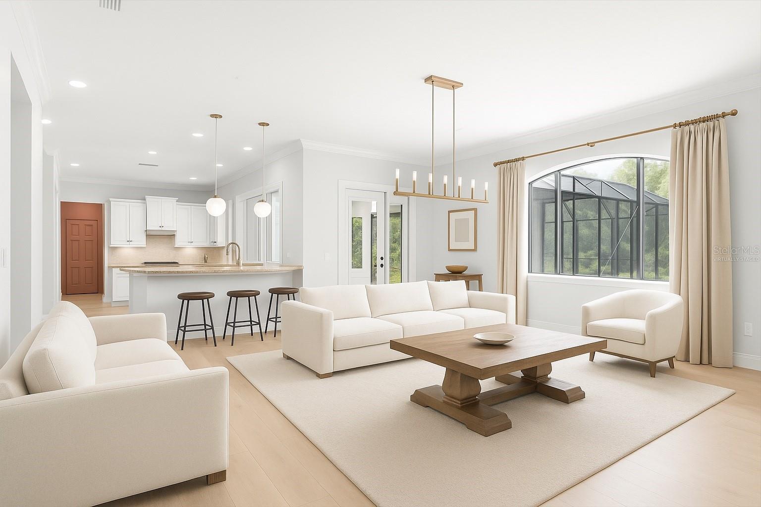 Open living room space adjacent to kitchen and view of pool and media room / movie theater / game room and virtually staged